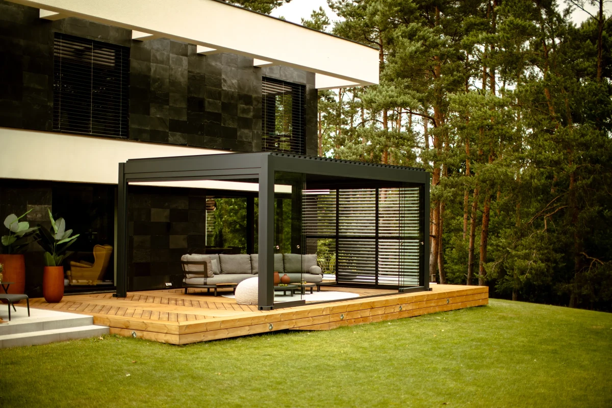 Pergola GRAND 6 × 4 m na dřevěné terase u moderního domu
